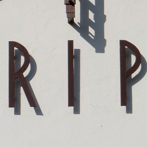 Helle Kapelle mit rotem Dach mit Aufschrift RIP