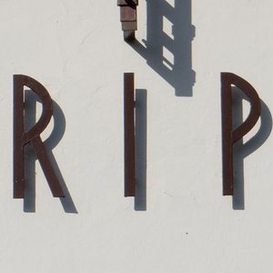 Helle Kapelle mit rotem Dach mit Aufschrift RIP