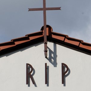 Helle Kapelle mit rotem Dach mit Aufschrift RIP