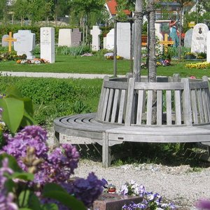 Runde Bank um einen Baum auf einem Friedhof