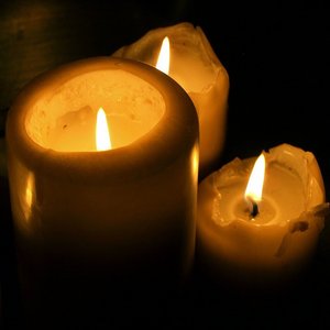 Vier brennende Kerzen in der Dunkelheit