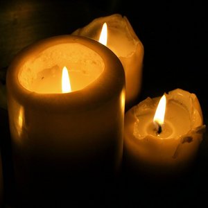 Vier brennende Kerzen in der Dunkelheit