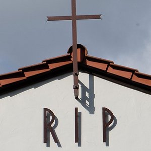 Kreuz und Schrift RIP am Giebel einer Trauerhalle